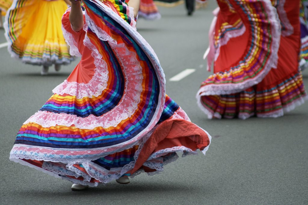 mexican american girl wearing traditional clothing and dancing.